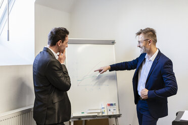 Two businessmen in office discussing at flip chart - DIGF06381