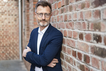 Portrait of confident businessman at brick wall - DIGF06382