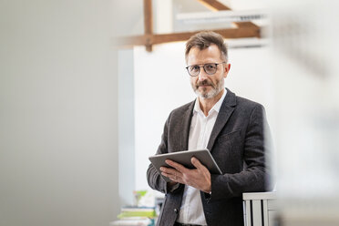 Porträt eines Geschäftsmannes, der ein Tablet im Büro benutzt - DIGF06392