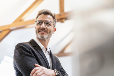 Portrait of smiling businessman in office looking away - DIGF06398