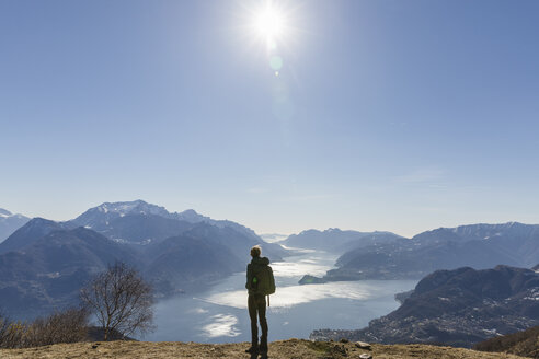 Italien, Como, Lecco, Frau beim Wandern in den Bergen oberhalb des Comer Sees, die die Aussicht genießt - MRAF00369