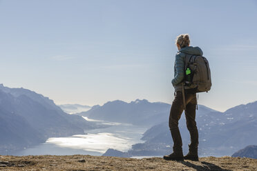 Italy, Como, Lecco, woman on a hiking trip in the mountains above Lake Como enjoying the view - MRAF00370