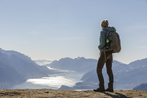 Italien, Como, Lecco, Frau beim Wandern in den Bergen oberhalb des Comer Sees, die die Aussicht genießt - MRAF00370