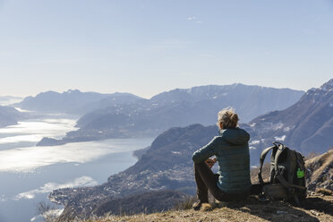 Italien, Como, Lecco, Frau beim Wandern in den Bergen oberhalb des Comer Sees, die die Aussicht genießt - MRAF00372