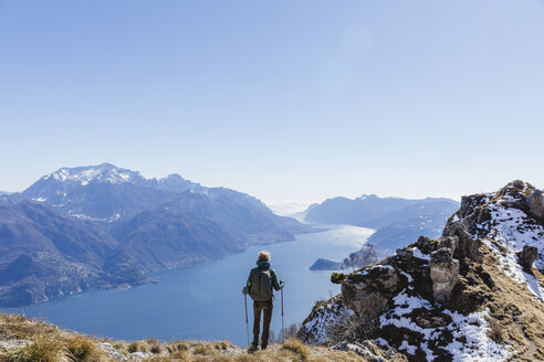 Italien, Como, Lecco, Frau beim Wandern in den Bergen oberhalb des Comer Sees, die die Aussicht genießt - MRAF00381