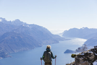 Italy, Como, Lecco, woman on a hiking trip in the mountains above Lake Como enjoying the view - MRAF00382