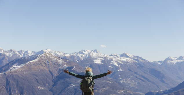 Italien, Como, Frau beim Wandern in den Bergen, die die Aussicht genießt - MRAF00388