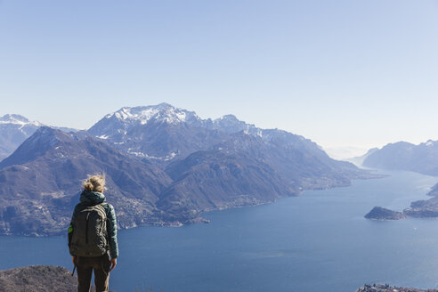 Italien, Como, Lecco, Frau beim Wandern in den Bergen oberhalb des Comer Sees, die die Aussicht genießt - MRAF00389