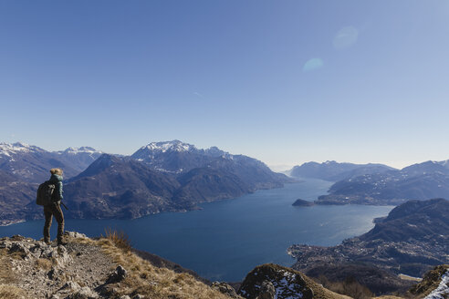 Italien, Como, Lecco, Frau beim Wandern in den Bergen oberhalb des Comer Sees, die die Aussicht genießt - MRAF00390