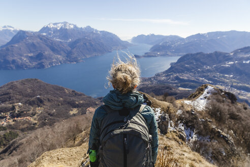 Italien, Como, Lecco, Frau beim Wandern in den Bergen oberhalb des Comer Sees, die die Aussicht genießt - MRAF00391