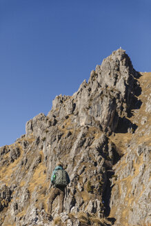 Italien, Como, Frau auf Wandertour in den Bergen mit Blick auf den Gipfel - MRAF00393