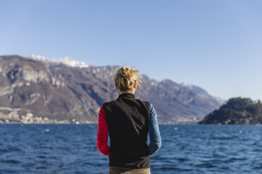 Italy, Como, rear view of woman enjoying the view of Lake Como - MRAF00400