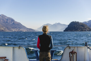 Italy, Como, rear view of woman on the ferry enjoying the view of Lake Como - MRAF00401