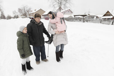 Großvater zusammen mit Tochter und Enkelkindern im Schnee - EYAF00025