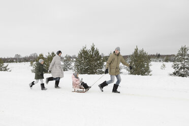 Family having fun with sledge in snow-covered landscape - EYAF00029