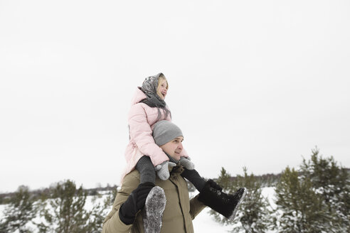 Vater trägt kleine Tochter auf den Schultern im Winter - EYAF00030