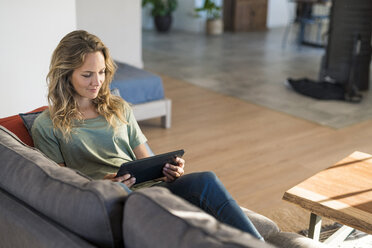 Woman realxing on couch at home using tablet - SBOF01971