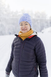 Finnland, Kuopio, Porträt einer lächelnden Frau in einer Winterlandschaft - PSIF00247