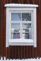 Finnland, Kuopio, kleines Mädchen schaut aus dem Fenster eines Bauernhauses im Winter - PSIF00248