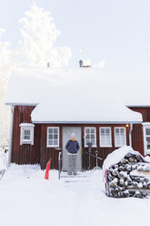 Finnland, Kuopio, Frau vor einem Bauernhaus im Winter - PSIF00250