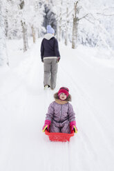Finland, Kuopio, mother and daugher sledging - PSIF00251