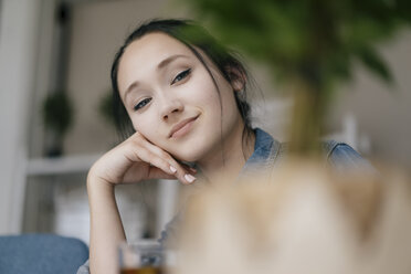 Portrait of smiling young woman behind a plant - KNSF05719