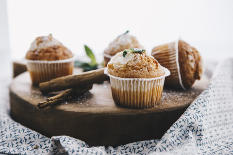 Selbstgebackene Muffins mit Zimt und Minze auf Holzbrett, lizenzfreies Stockfoto