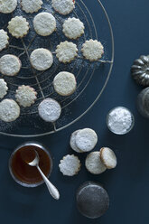 Christmas Cookies Spitzbuben on a baking grid, jam in a jar, Rosehip Jam, icing sugar - ASF06318