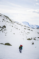 Rückansicht eines Mannes mit Rucksack, schneebedeckte Berge - ACPF00497