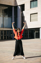 Young contemporary dancer wearing red hoodie shirt, practicing her passion - JRFF02879