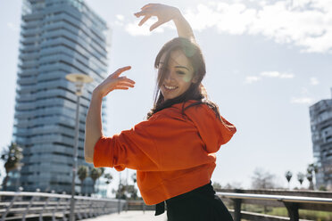 Young contemporary dancer wearing red hoodie shirt, practicing her passion - JRFF02882