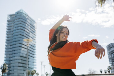 Young contemporary dancer wearing red hoodie shirt, practicing her passion - JRFF02883