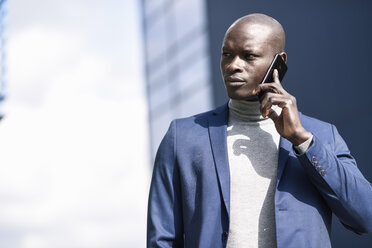 Porträt eines Geschäftsmannes im blauen Anzug am Telefon - JSMF00875