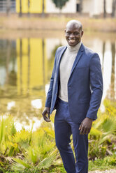 Porträt eines eleganten Geschäftsmannes in blauem Anzug und grauem Rollkragenpullover - JSMF00908