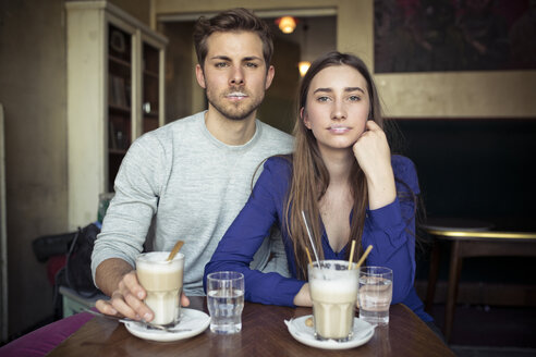 Porträt eines jungen Paares in einem Café mit Milchschaum auf den Lippen - PNEF01327