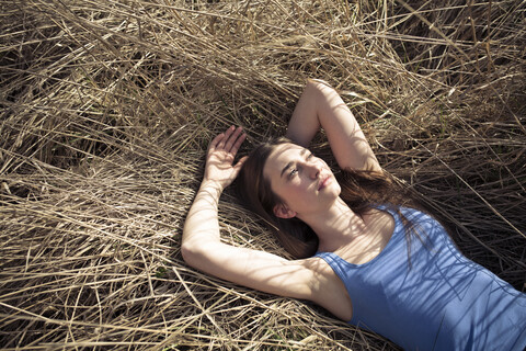 Relaxed young woman lying in meadow stock photo