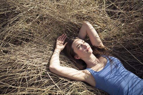 Relaxed young woman lying in meadow - PNEF01329