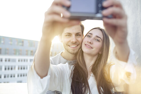 Lächelndes junges Paar macht ein Selfie im Freien - PNEF01347
