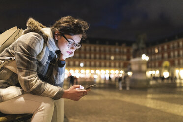 Spanien, Madrid, Plaza Mayor, junge Frau benutzt ihr Smartphone - WPEF01386