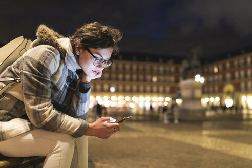 Spanien, Madrid, Plaza Mayor, junge Frau benutzt ihr Smartphone - WPEF01386