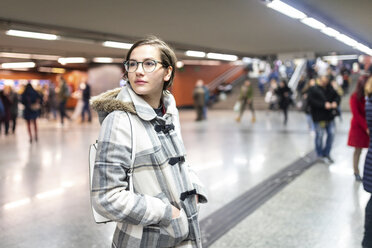 Spanien, Madrid, junge Frau in einer belebten U-Bahn-Station - WPEF01408