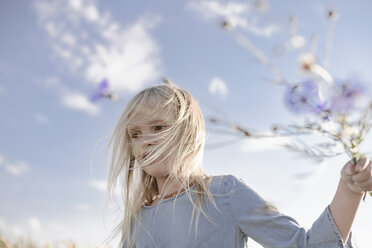 Blondes Mädchen mit zerzaustem Haar hält Kornblumen - EYAF00039