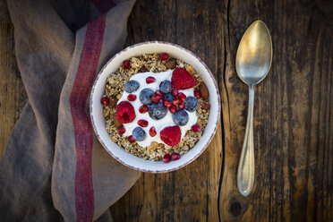 Bowl of muesli with Greek yogurt, popped quinoa, raspberries, blueberries and pomegranate seeds, from above - LVF07905