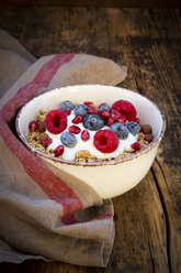 Bowl of muesli with Greek yogurt, popped quinoa, raspberries, blueberries and pomegranate seeds, from above - LVF07907