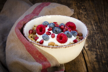 Bowl of muesli with Greek yogurt, popped quinoa, raspberries, blueberries and pomegranate seeds, from above - LVF07908