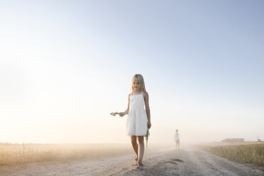 Girl walking on a rural dirt track - EYAF00056