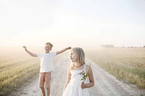 Mädchen und Junge auf einem ländlichen Feldweg, lizenzfreies Stockfoto