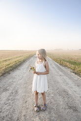Girl standing on a rural dirt track - EYAF00059