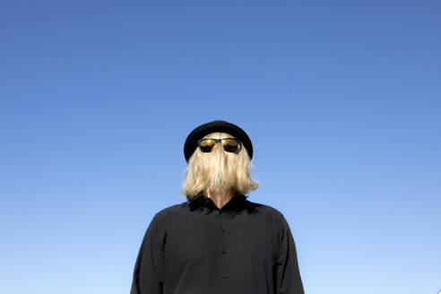 Blondes Haar verdeckt das Gesicht eines Mannes mit Sonnenbrille und Melone - PSTF00366