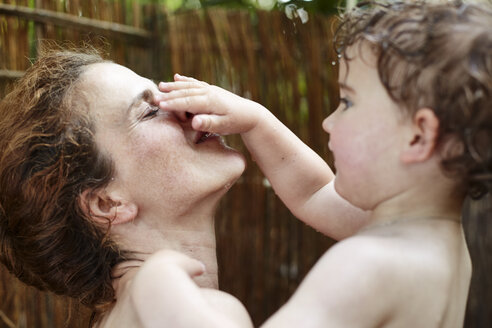 Mutter und kleine Tochter nehmen eine Dusche im Freien und haben Spaß - AMEF00044
